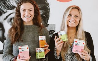 Daisy Williams and Hannah Smith smiling and holding hey girls products in their hands