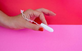 non applicator Tampon held between fingers to show size